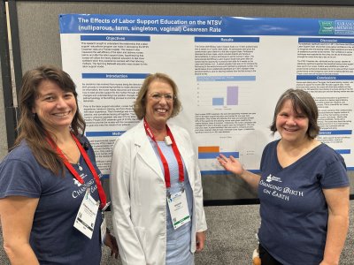 Bridget Funk, RN, stands in front of her presentation poster on Spinning Babies accompanied by Gail Tully and Jennifer Walker